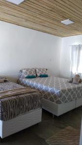 two beds sitting next to each other in a bedroom at Pousada Cristal - Caraiva in Porto Seguro