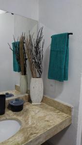 a bathroom with a sink and a green towel at Pousada Cristal - Caraiva in Porto Seguro