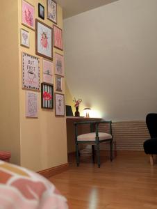 a room with a table and a chair and pictures on the wall at Chambre privée, A l'ombre des Pommiers in Croix-Mare