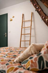 a dog laying on a bed next to a ladder at Chambre privée, A l'ombre des Pommiers in Croix-Mare