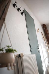 a door with animals on the wall next to a plant at Chambre privée, A l'ombre des Pommiers in Croix-Mare +2 photos