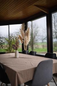 a dining room table with chairs and a large window at Chambre privée, A l'ombre des Pommiers in Croix-Mare