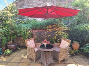 a table and two chairs with a red umbrella at 19 Upper Linney in Ludlow