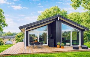 a black shed with a table and chairs on a deck at 3 Bedroom Awesome Home In Haderslev in Haderslev +9 photos