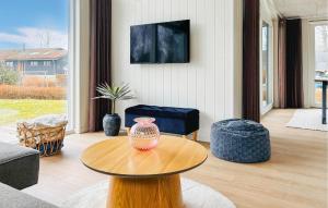 a living room with a vase on a wooden table at 3 Bedroom Awesome Home In Haderslev in Haderslev