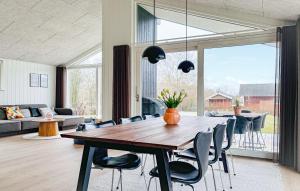 a living room with a wooden table and chairs at 3 Bedroom Awesome Home In Haderslev in Haderslev
