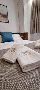 two white towels sitting on top of a bed at SKYLINE apartments Kopaonik in Kopaonik +26 photos