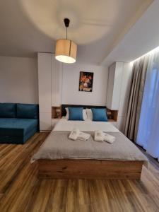 a bedroom with a large bed and a blue couch at SKYLINE apartments Kopaonik in Kopaonik