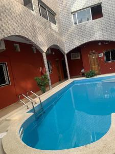 a swimming pool in front of a building at Sall Africa Tourisme in Mbour