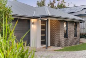 a house with a garage with a roof at JOT Luxe Haven in Narangba