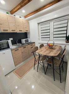 a kitchen with a table and chairs in a kitchen at Apartman Martinović in Županja