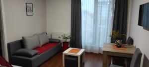 a living room with a couch and a table at Apartmani METRO in Loznica