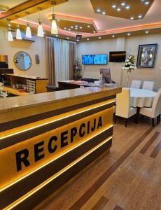 a hotel lobby with a reception counter and a restaurant at Villa Atina in Stara Pazova