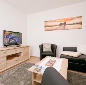 a living room with a couch and a tv at Ferienhaus Herbert in Groß Kordshagen
