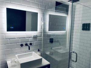 a white bathroom with a sink and a mirror at Valle 20 Villa Moderna con Alberca Privada Mayores 12 años in San Antonio de las Minas +29 photos
