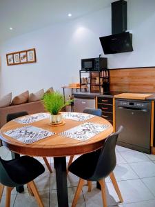a kitchen with a table and chairs in a room at Appartement cosy et confortable Chez Lyne in Laragne