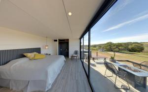 a bedroom with a bed and a balcony at Valle 20 Villa Moderna con Alberca Privada Mayores 12 años in San Antonio de las Minas