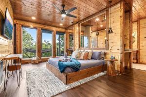 a bedroom in a log cabin with a bed and windows at Gatlinburg Amazing Views-EV Chrger - Firepit, Spa Shower and Jacuzzi,Hot Tub in Gatlinburg