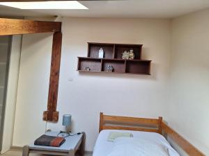 a bedroom with a bed and a shelf on the wall at Petite maison proche cathédrale hyper centre in Toul