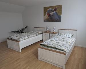ein Zimmer mit zwei Betten und einem Gemälde an der Wand in der Unterkunft Kornkammer - Ferienhaus NaheZeit Bostalsee in Nohfelden