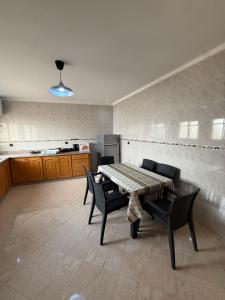 a dining room with a table and chairs and a kitchen at Modern Apartment Driouch 1 in Driouch