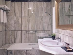 a bathroom with a sink and a shower at Hotel Du Lac Congress Center & Spa in Ioannina