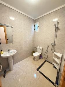 a bathroom with a shower and a toilet and a sink at Modern Apartment Driouch 1 in Driouch +9 photos