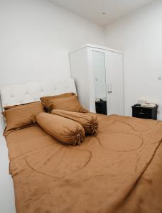 a bed with pillows on it in a bedroom at Haus Strahlende Villa in Batu