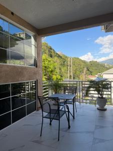 a patio with a table and chairs on a balcony at 360 RokView Suites 3BR Spacious in Kingston