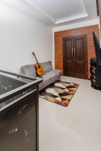 a living room with a couch and a guitar at Haus Strahlende Villa in Batu