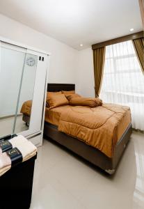 a bedroom with a bed and a mirror at Haus Strahlende Villa in Batu