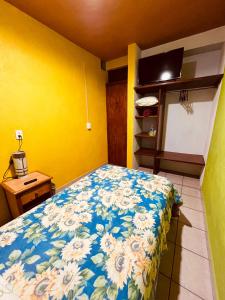 a bedroom with a bed and a yellow wall at Casa Dos Arbolitos in Ciudad Nezahualcóyotl