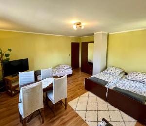 a room with two beds and a table with chairs at Pod Modrzewiem in Pogorzelce