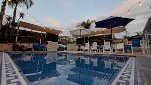 a swimming pool with chairs and umbrellas on a building at Byblos inn, jbeil ,Fidar in Al Fīdār