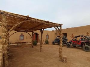 a wooden pavilion in front of a building at Maggaman Guest House in Tafraoute Sidi Ali
