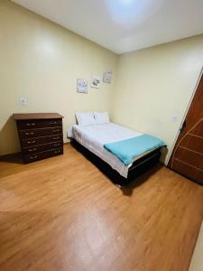 a bedroom with a bed and a dresser in it at Hostel Cünhatã in Belém
