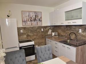 a kitchen with white cabinets and a sink at Kuca za Odmor ISKRA in Mokra Gora