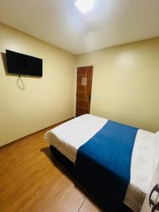 a bedroom with a bed and a flat screen tv at Hostel Cünhatã in Belém