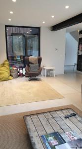 a living room with a chair and a table at Tomorrowland2026 Basecamp in Mechelen +3 photos