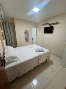 a bedroom with a bed and a tv on the wall at Hostel Cünhatã in Belém +16 photos