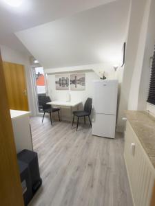 a kitchen with a table and chairs and a white refrigerator at HanseSuite zentral & charmante Ferienwohnung in Lübeck +8 photos