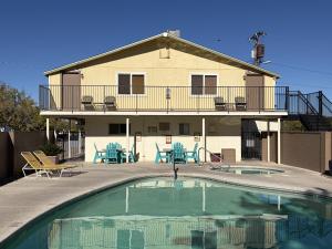 a house with a swimming pool in front of a house at Kingman KOA in Kingman