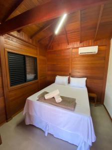 a bedroom with a bed in a wooden room at Cerrado da Canastra Chalés in São Roque de Minas