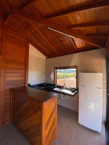a kitchen with a white refrigerator and a window at Cerrado da Canastra Chalés in São Roque de Minas +17 photos