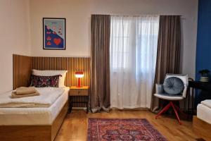 a bedroom with a bed and a window with a chair at FEWOCASA Central Family Apartment Rorschach - Lake Constance - Near St Gallen in Rorschach