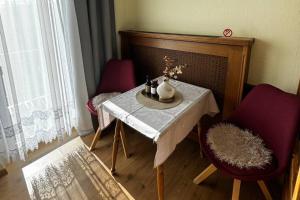 a table with two chairs and a vase with flowers on it at Gästehaus 3-Länderblick-Panoramablick in Mönichkirchen