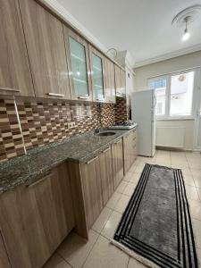 a kitchen with wooden cabinets and a refrigerator at Lale Residence in Trabzon