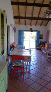 a kitchen with a table with a red chair in a room at Casa Los colibrí in Frente Mar