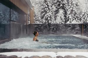 a woman in a hot tub in the snow at Hotel Kirchenwirt in Kaunertal