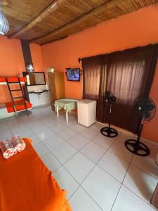 a living room with orange walls and a couch at Punta Pacífico Bungalows Máncora in Máncora